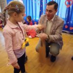 Dziewczynka odbiera nagrodę z rąk pana burmistrza