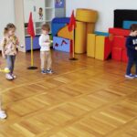 Dzieci biegną z jajkami na łyżce