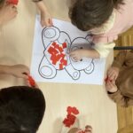 Dzieci wyklejają misia