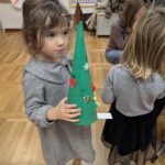 Dziewczynka prezentuje wykonaną choineczkę