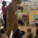 Miś przybija piątki dzieciom