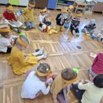 Dzieci słuchają książki pt. Kubuś Puchatek, którą czyta nauczycielka