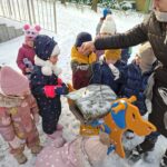 Dzieci sypią ziarna dla ptaków