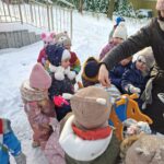 Dzieci wsypują do karmnika ziarenka