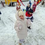 Dziewczynka i chłopiec bawią się na śniegu