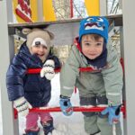 Dziewczynka i chłopiec bawią się na sprzęcie na placu zabaw