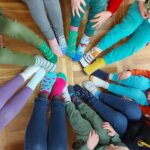 Dzieci pokazują kolorowe skarpetki nie do pary